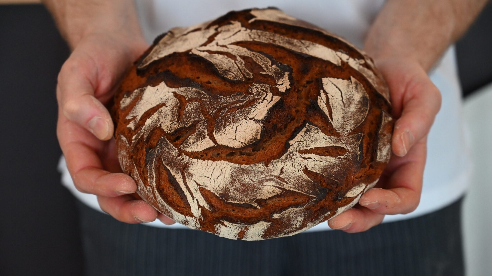 Bäcker, Metzger, das Handwerk - ohne sie alle wäre der Tourismus nicht das, was er ist. Das Bild zeigt einen Laib Brot mit dunkler Kruste in den Händen eines Bäckers., © Kerstin Riemer Bäcker, Metzger, das Handwerk - ohne sie alle wäre der Tourismus nicht das, was er ist. Das Bild zeigt einen Laib Brot mit dunkler Kruste in den Händen eines Bäckers., © Kerstin Riemer