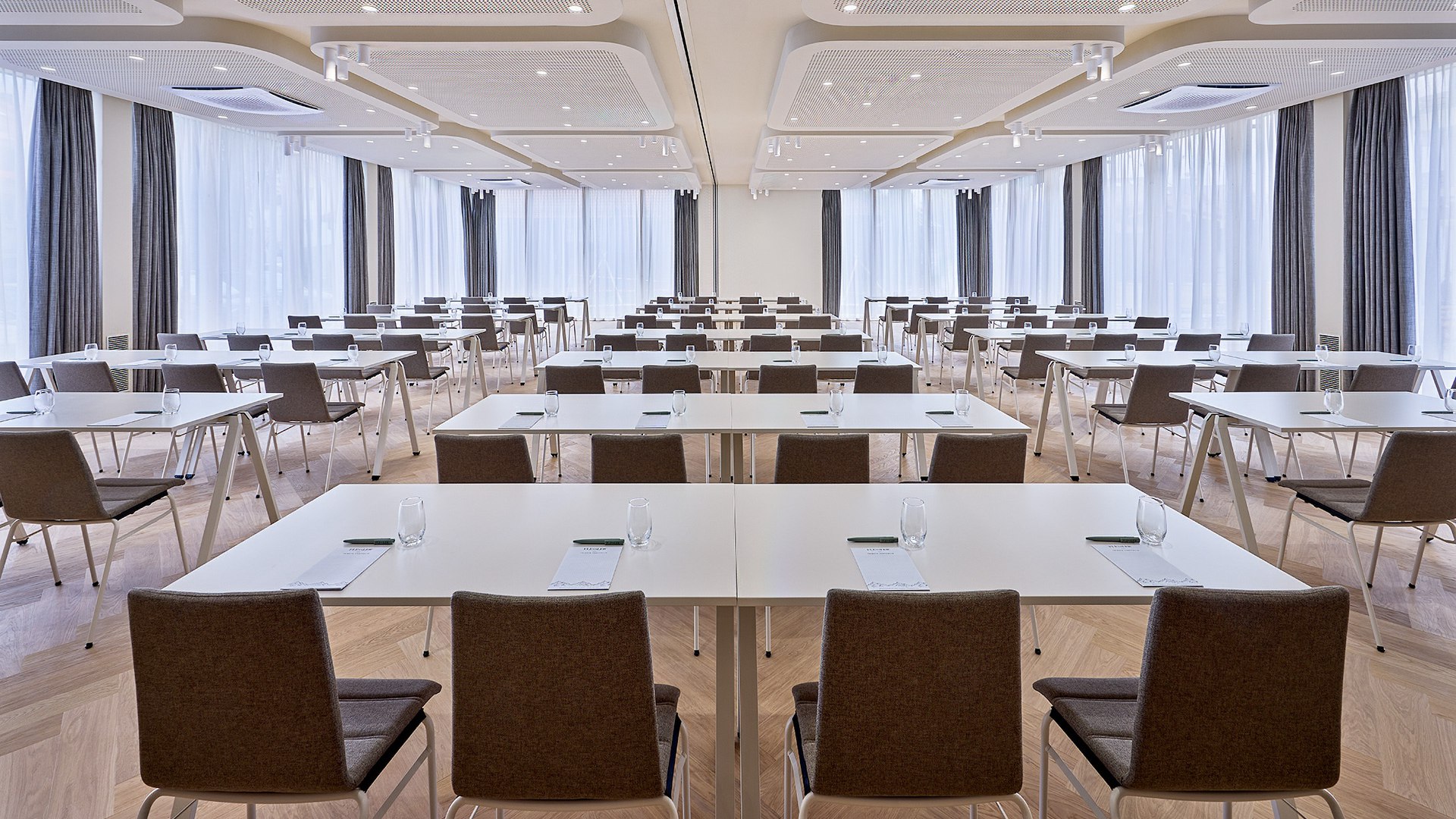 Stilvoll Tagen mit modernster Technik wie hier im Raum "Weltcuphang" des Flesslers Lenggries.
Das Bild zeigt einen lichtdurchfluteten Tagungsraum mit Tischreihen-Bestuhlung. , &copy; Flesslers Lenggries, Tribute Portfolio Marriott, Foto: Matthias Hamel