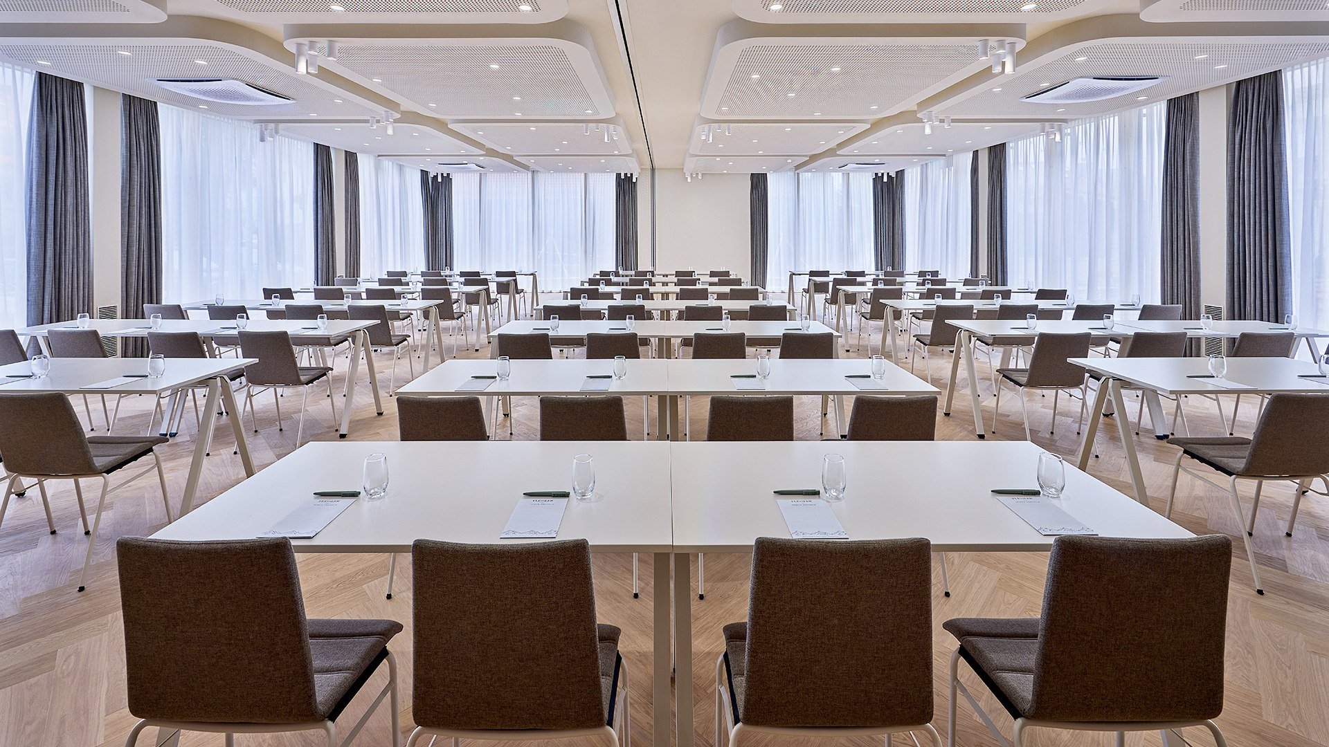 Stilvoll Tagen mit modernster Technik wie hier im Raum "Weltcuphang" des Flesslers Lenggries.
Das Bild zeigt einen lichtdurchfluteten Tagungsraum mit Tischreihen-Bestuhlung. , &copy; Flesslers Lenggries, Tribute Portfolio Marriott, Foto: Matthias Hamel