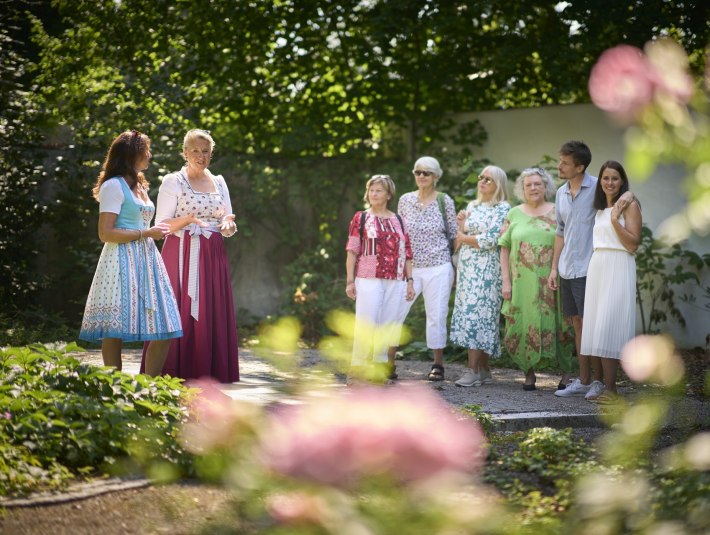 Zwei Stadtführerinnen mit einer Gästegruppe bei einer Stadtführung durch das sommerlich-grüne Bad Tölz, © Stadt Bad Tölz