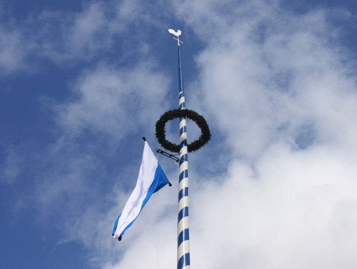 Maibaum unter blau-weißem Himmel , © TLT Kirschenhofer