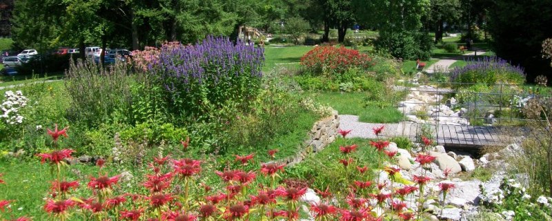 &Uuml;ppige Bl&uuml;tenpracht und alter Baumbestand im Parkgel&auml;nde, den ein kleiner Bachlauf mit kleinen Br&uuml;cken durchzieht., &copy; G&auml;steinformation Bad Heilbrunn