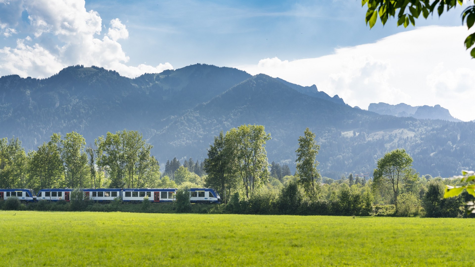 Mit der Bayerischen Regiobahn durch blühende Wiesen durch das Isartal bei Lenggries mit Blick auf's Brauneck, © Bayerische Regionbahn GmbH