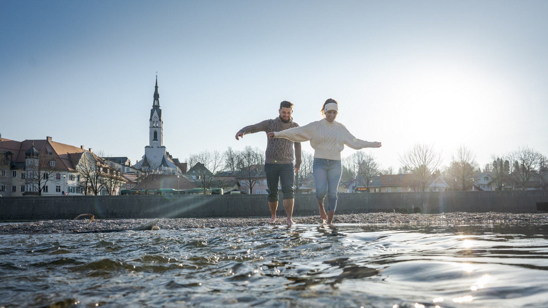 Balsam f&uuml;r die Seele - Ein Spaziergang an der Isar bei Bad T&ouml;lz im Sp&auml;twinter. Ein P&auml;rchen stakst barfu&szlig; durch das eiskalte Wasser der Isar bei Bad T&ouml;lz, &copy; T&ouml;lzer Land Tourismus|Leonie Lorenz