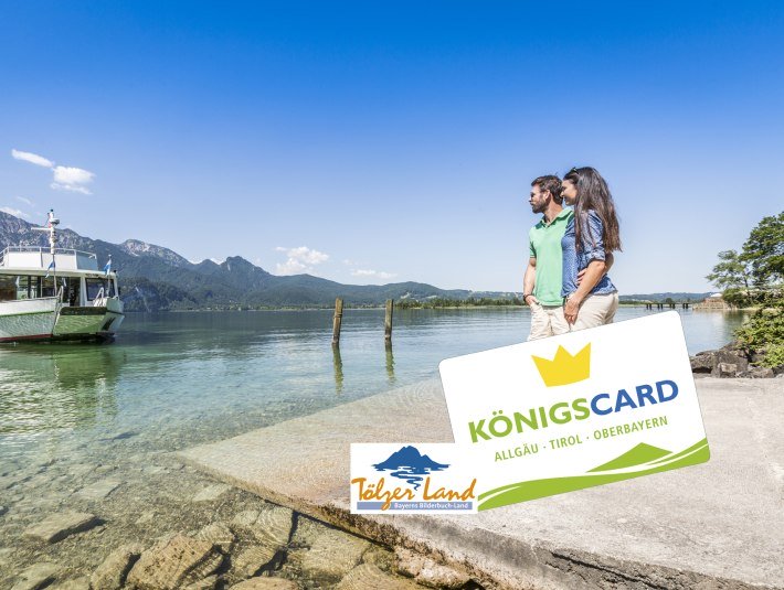 Die Königscrad  - bei ausgewählten Gastgebern erhältlich für ein MEHR an Urlaubsspaß. Das Bild zeigt ein auf das Kochelseeschiff wartenede Pärchen am Steg mit den Logos der Königscard Gästekarte und dem Logo von Tölzer Land Tourismus, © Foto: TI Kochel a. See|Thomas Kujat