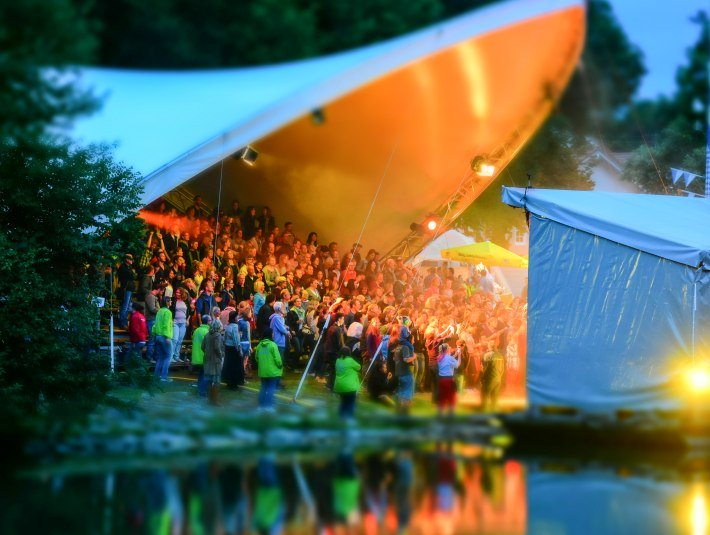 Bühne mit Menschen an der Loisach , © Tom Hirschmann