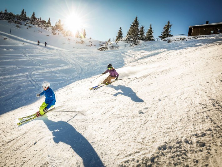 Zwei Skifahrer sausen die Piste hinunter, © Tourist Information Kochel a. See, Fotograf Kujat