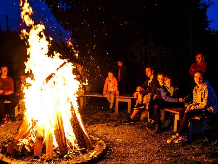 Das geh&ouml;rt bei vielen Gruppenangeboten der Jugendherberge Bad T&ouml;lz dazu - ein gro&szlig;es Lagerfeuer, bei dem man sich &uuml;ber die Erlebnisse des Tages austauscht und die wohlige W&auml;rme des knisternden Feures genie&szlig;t., &copy; Deutsches Jugendherbergswerk Landesverband Bayern e.V.