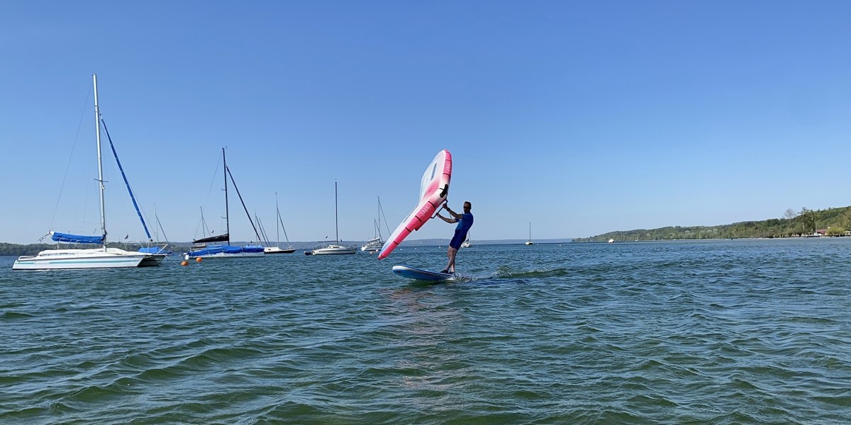 Ein Wingfoiler des Wassersportcenters am Starnberger See h&auml;lt sein rot-wei&szlig;es Foil, &copy; Wassersportcenter Starnberger See, Foto: Wallusch