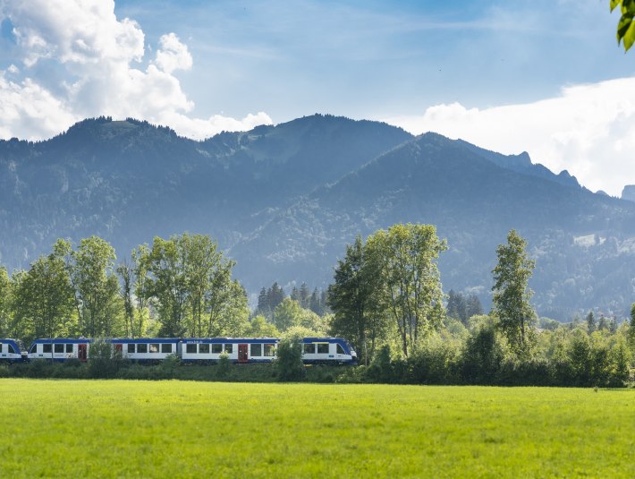 Mit der Bayerischen Regiobahn durch blühende Wiesen durch das Isartal bei Lenggries mit Blick auf's Brauneck, © Bayerische Regionbahn GmbH